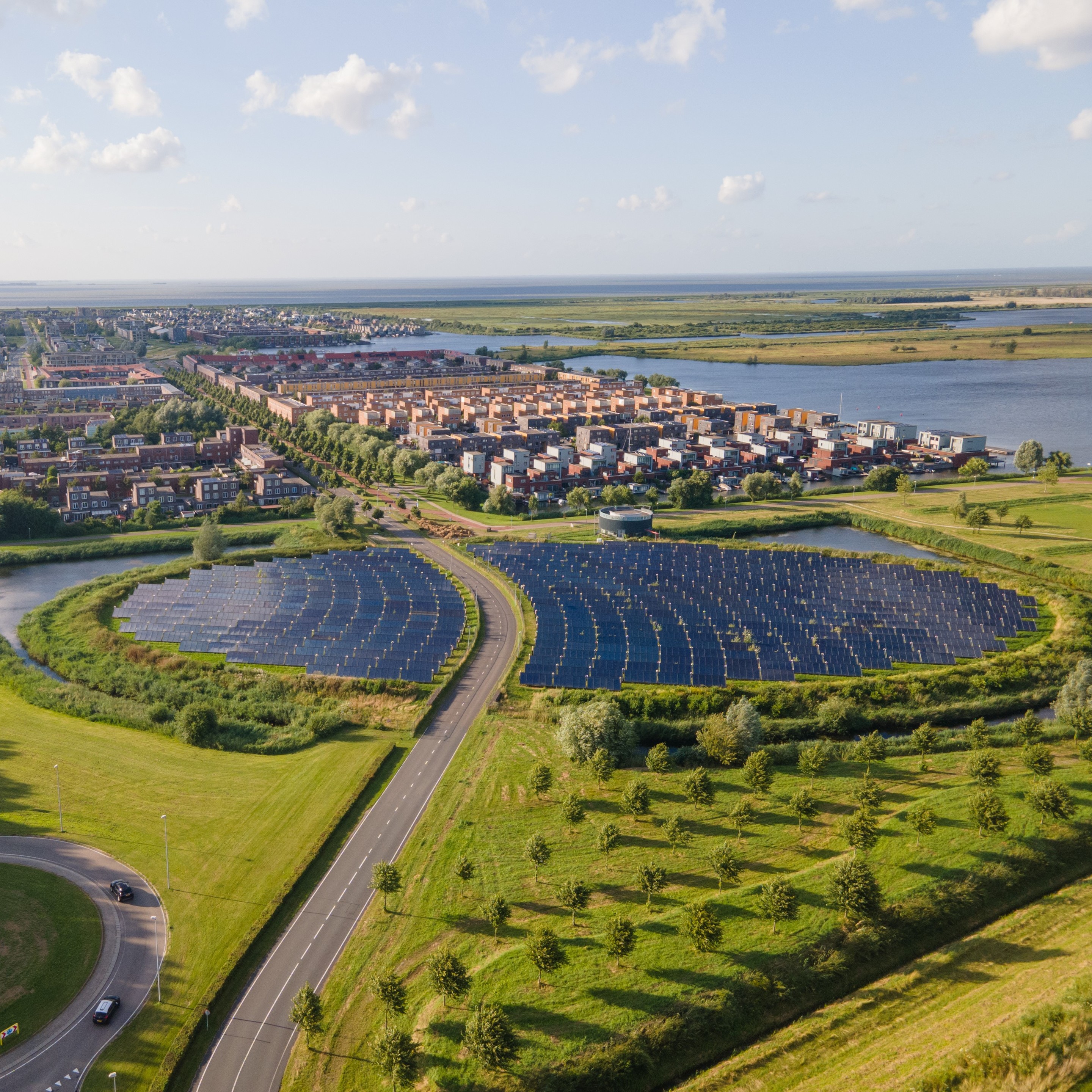 A photo of a solar park in the Netherlands in a round shape next to a residential area